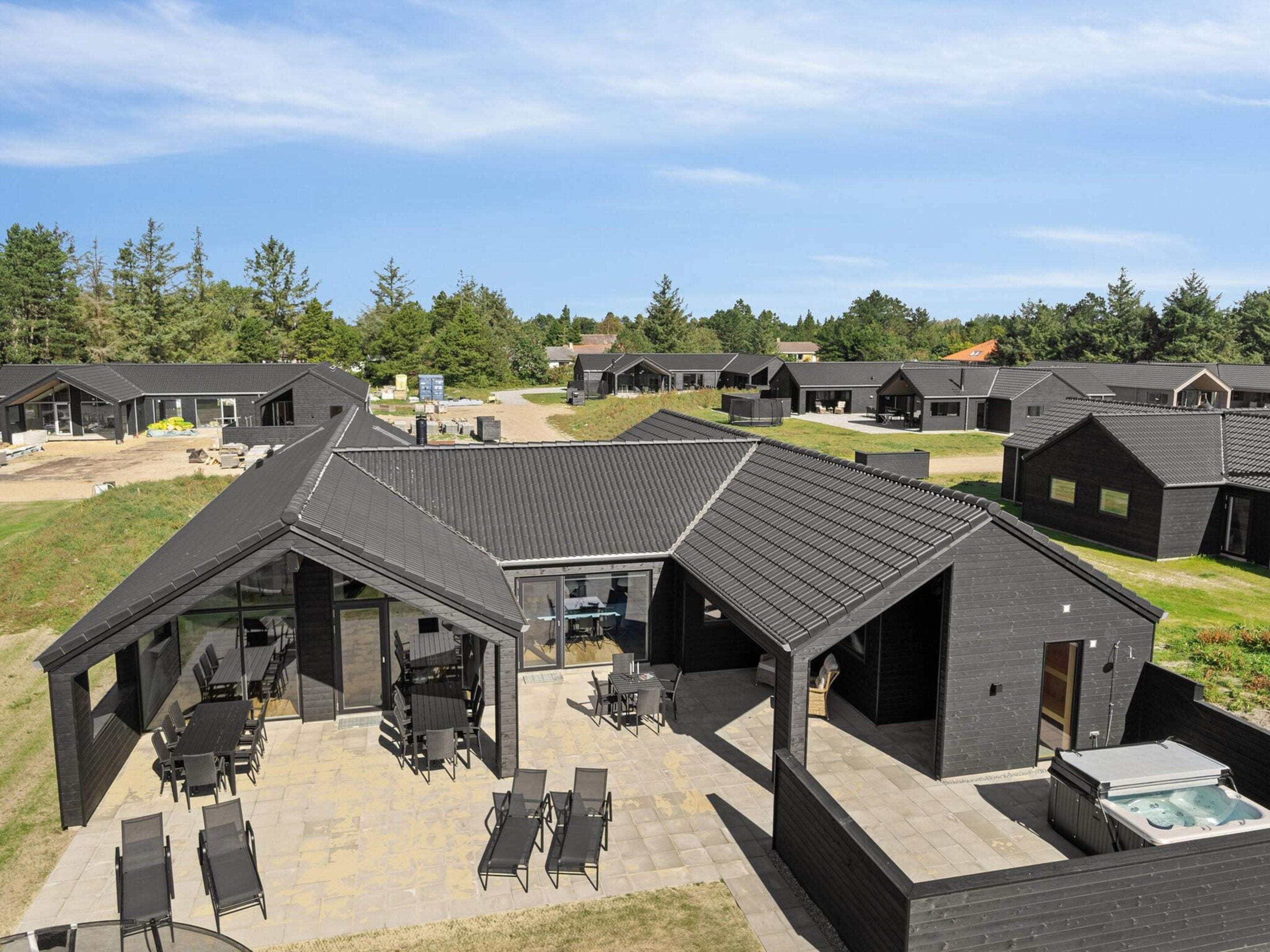 A modern outdoor area with a covered seating area and a hot tub.