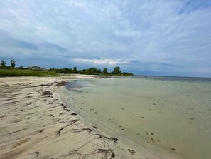 A beach with clear water, a sandy shore, and a building in the background. - 8 Person Holiday Home in Borgholm (Borgholm)