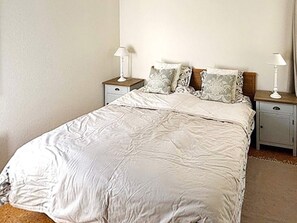 A single-bed room with a white bedspread, two bedside tables with lamps, and a nightstand with a lamp. - 8 Person Holiday Home in Borgholm (Borgholm)