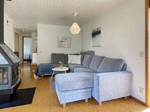 A modern living room with a sectional sofa, a small round table, and a hanging light fixture. - 8 Person Holiday Home in Borgholm (Borgholm)