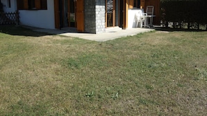 Une maison moderne à deux étages, avec des fondations en pierre, un revêtement extérieur en bois et un patio couvert.