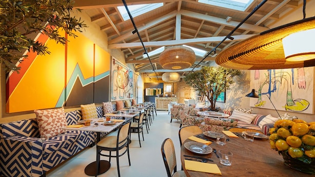 A spacious dining area with high ceilings, exposed beams, and natural light. Tables are set for dining, and there are decorative plants and artwork on the walls. - THE PINTA Boutique Hotel (Armamar)