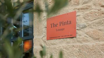 Un letrero que dice 'The Pintah Lounge' sujeto a una pared de piedra.
