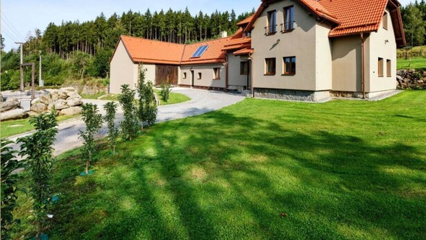 A large house with a red-tiled roof, multiple windows, and a well-maintained lawn. - Charming Villa With Internet (Varvažov)