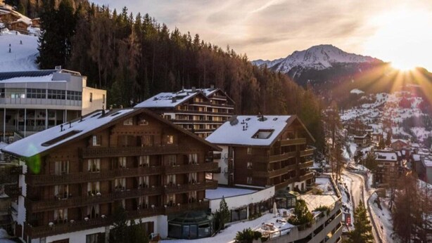 A ski resort with wooden lodges, a modern building, and a mountain backdrop. - Apartment With Alpine Gateway (Veysonnaz)
