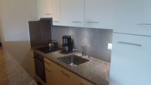 A compact kitchen with two sinks, a coffee maker, and a kettle. - Beaulieu F 014 Center Apartment 5 Pers (Veysonnaz)
