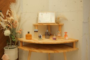 Una mesa de madera con varias botellas de perfume y un cartel enmarcado.