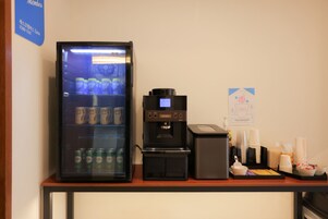 A self-service beverage station with a refrigerated drink dispenser and a coffee machine.