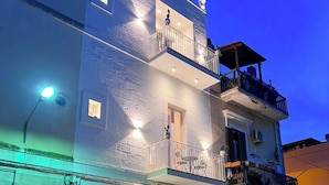 A multi-story building with balconies, a small outdoor seating area, and a street-facing entrance. - Dimora Bianca Luxury (Conversano)