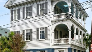 A two-story building with a balcony and a blue door. - Thomas Waring House | Unit B | Sleeps 4 (Charleston)