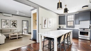 Una cocina moderna con armarios oscuros, encimera blanca y estufa de acero inoxidable.