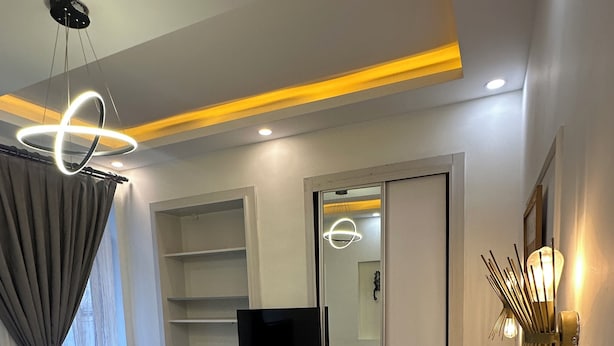 A hotel room with a bed, a desk, a chair, a television, a wardrobe, and a mirror. - new arcadia taksim (Istanbul)
