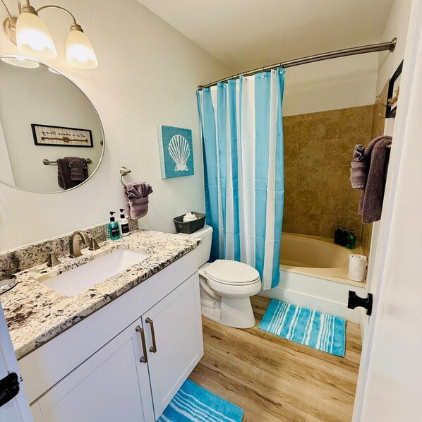 A bathroom with a sink, toilet, and shower.