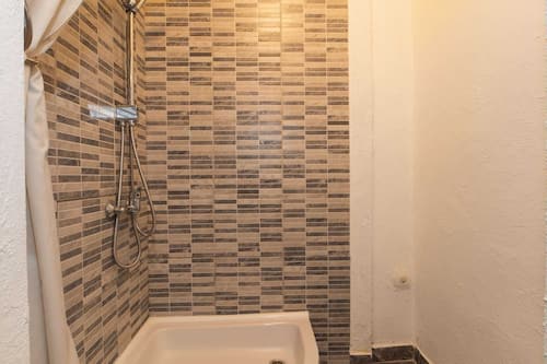 Studio (Studio Apartment with Garden) | Badkamer | Een douche, handdoeken