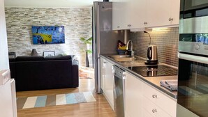 Eine moderne Küche mit Edelstahlgeräten, einer gefliesten Spritzschutzwand und Holzboden.
