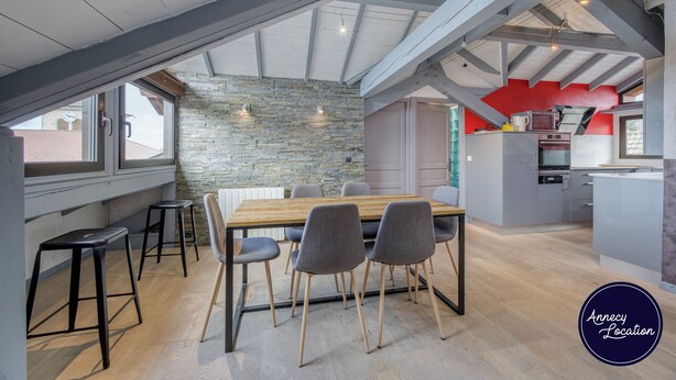 Una cocina moderna con pared de piedra, vigas de madera y una pared de acento roja.