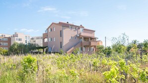 Un immeuble résidentiel à plusieurs étages, doté d’un toit plat et d’un balcon.