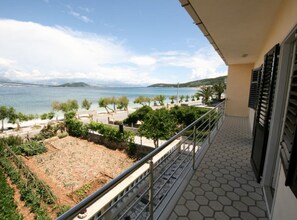 A balcony with a view of a coastal area, including a body of water and distant mountains. - Spacious Beachfront Apartment Ciovo (Split)