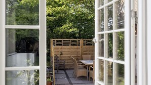 A patio with a wooden fence, wicker furniture, and potted plants. - 4 Star Holiday Home in Saeby (Sæby)
