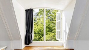 A room with a window overlooking greenery, a wooden ledge, and a black chair. - 4 Star Holiday Home in Saeby (Sæby)