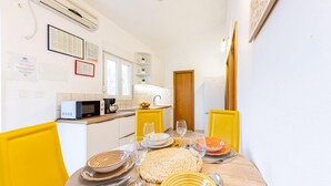 A compact kitchen with a microwave, sink, and yellow chairs. - Spacious Prgomet Retreat With Private Pool, Fitness Centre, and Garden (Prgomet)