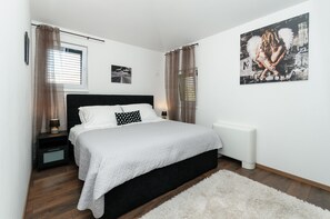 Relax in a serene space with a large bed, bedside table, and framed artwork.