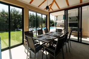 Enjoy meals with family and friends in this spacious dining area, surrounded by an outdoor space with a swimming pool.
