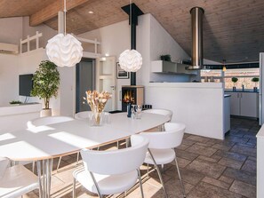A modern kitchen with white cabinetry, a central island, and hanging pendant lights. - 4 Star Holiday Home in Ronde (Ronde)