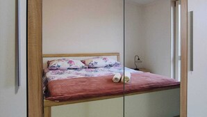A bedroom with a bed, a mirror cabinet, and a ceiling light. - Kastel Stafilic Comfortable Apartments (Kastela)