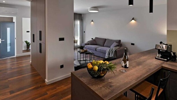 A modern kitchen with a wooden countertop, a bowl of fruit, and a coffee machine. - Luxury Slatine Apartments With Terrace and Garden (Split)