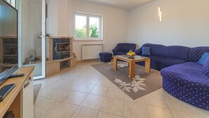 A living room with a sofa, a coffee table, a fireplace, and a window. - Idyllic Getaway Lovrec Villa With Pool (Lovrec)