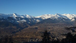 A mountainous landscape with snow-capped peaks and a valley with a town. - Lovely Apartment With Mountain Views (Veysonnaz)