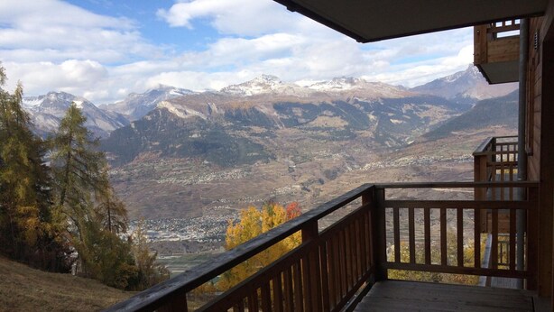 A wooden balcony with a view of a mountainous landscape. - Lovely Apartment With Mountain Views (Veysonnaz)
