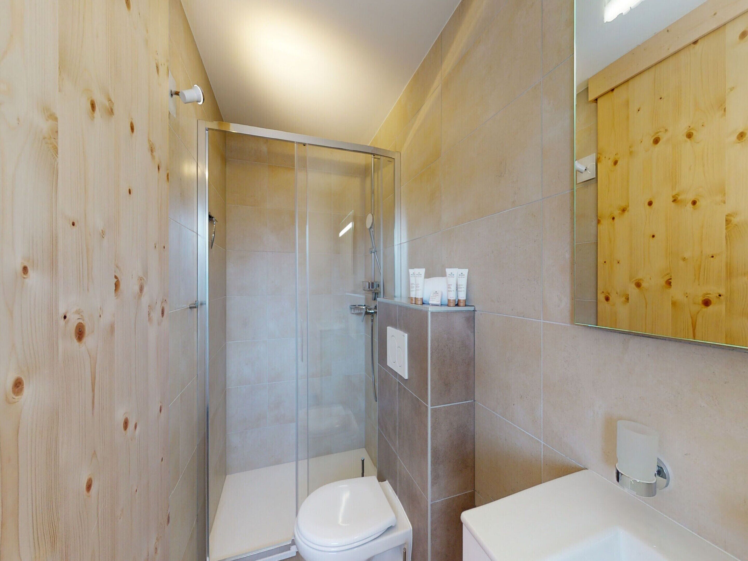 Ein modernes Badezimmer mit einer Duschkabine, einer Toilette und einem Waschbecken.