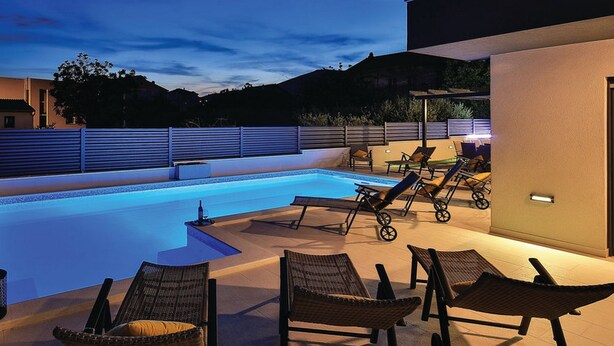 A modern outdoor pool area with lounge chairs and a pergola. - Modern Kastel Villa With Private Pool, Gym, and Large Outdoor Space (Kastela)