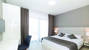 A modern hotel room with a large bed, a desk, and a chair. - Modern Kastel Villa With Private Pool, Gym, and Large Outdoor Space (Kastela)