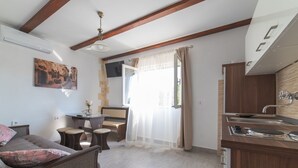 A modern kitchen with a built-in stove, a dining area with a table and chairs, and a living room with a sofa and a TV. - Serene Retreat Holiday Home With Pool (Klis)