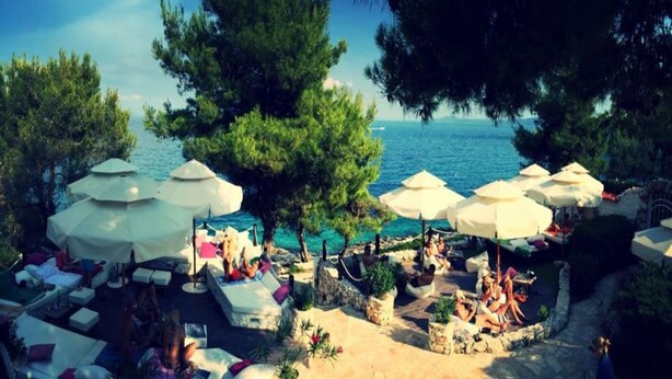 Una località balneare con zone relax all'aperto, ombrelloni e vista sul mare.