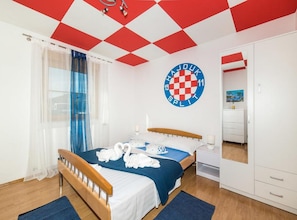 Ein Hotelzimmer mit Bett, Spiegel, Kleiderschrank und einer Wand mit einem Logo.