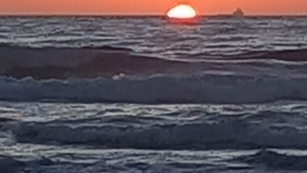 A sunset over the ocean with waves approaching the shore. - Magnificent apartment with green spaces 2 minutes walk from Houara-Tanger beach (Tanger)