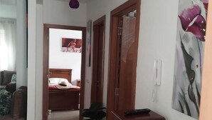 A hotel room with a bed, a desk with a computer, a chair, a potted plant, and a painting on the wall. - Magnificent apartment with green spaces 2 minutes walk from Houara-Tanger beach (Tanger)
