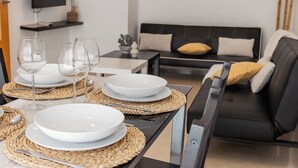 A dining area with a table set for four, including plates, glasses, and cutlery. - Apartamentos LA PARRETA CENTRO (Vinaros)