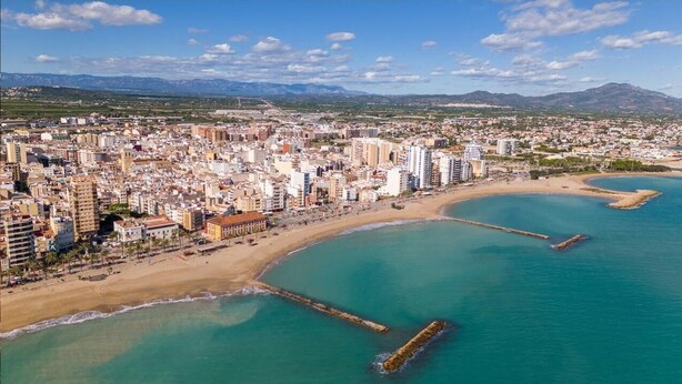 An aerial view of a coastal city with a beach, buildings, and mountains in the background. - Apartamentos LA PARRETA CENTRO (Vinaros)