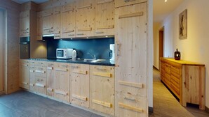 A modern kitchen with wooden cabinetry and a black countertop.