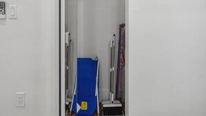 A room with a white wall, a wooden floor, a blue storage unit, and a metal ladder. - Casa Roselle full 2/2 (Hollywood)