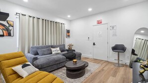 A modern living room with a grey sofa, a mustard-colored armchair, and a round coffee table. - Casa Roselle full 2/2 (Hollywood)