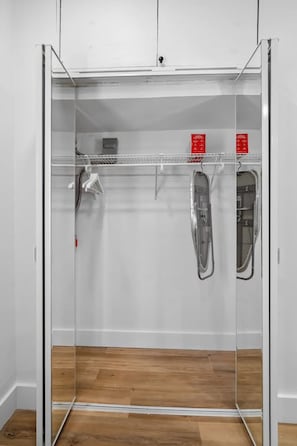 Un armario de vestidor con espejo, un perchero y un zapatero.