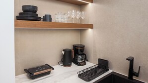 A kitchen with a coffee maker, a kettle, and a keyboard on the counter. - Stylish Modern Suite at Piraeus Port (Piraeus)