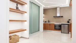 A modern kitchen with wooden shelves, a built-in oven, and a stainless steel refrigerator. - Stylish Modern Suite at Piraeus Port (Piraeus)