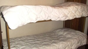 A bunk bed with a white quilted mattress and a wooden frame. - Pleasant Apartment With Balcony (Veysonnaz)